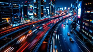 Long-exposure photograph of Tokyo expressway traffic at night with light trails curving between illuminated high-rise buildings